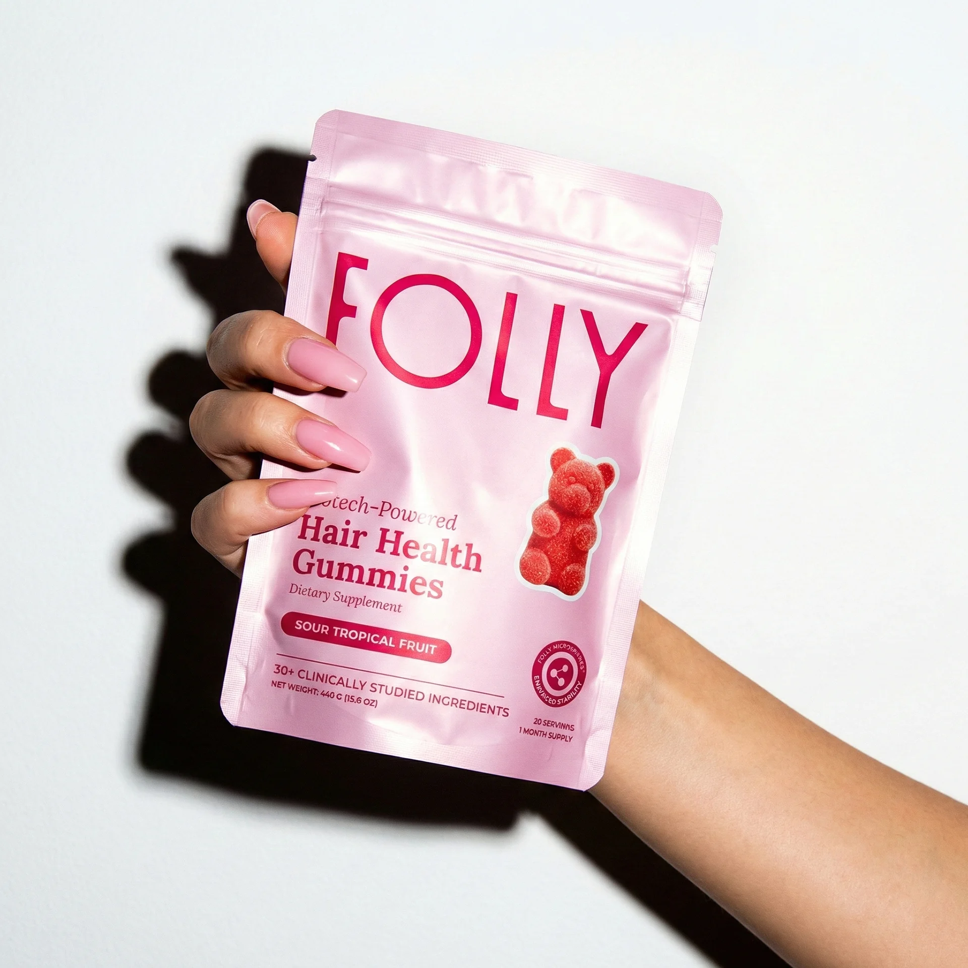 Folly Hair Health Gummies pouch held in hand